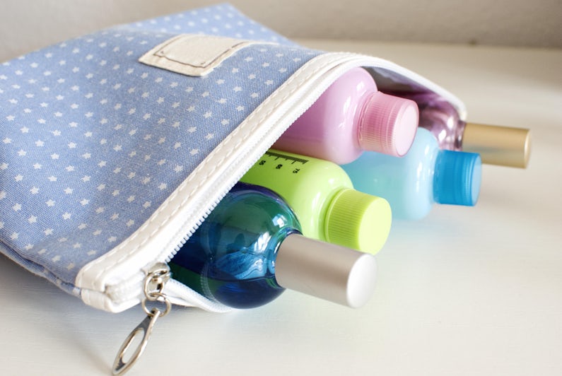 Close-up shot of an open toiletry bag, filled with small bottles of soap and shampoo