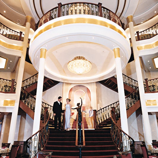 Couple dressed up for formal night on the grand staircase of the Main Dining Room on Navigator of the Seas