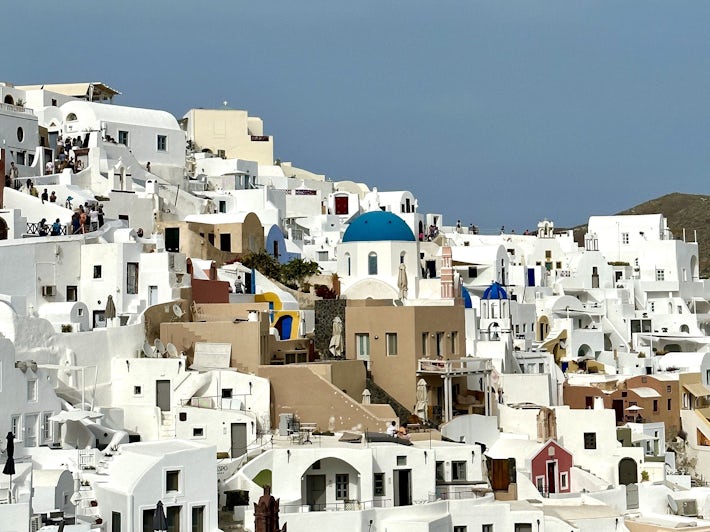 View of Oia on Santorini from town center with blue church dome