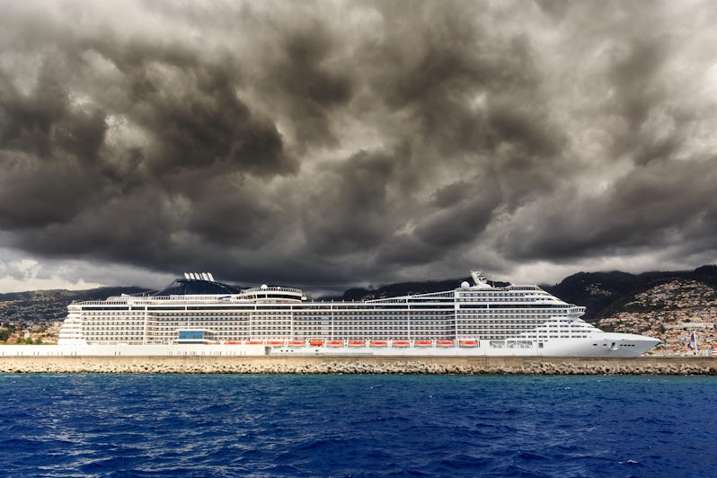 Beautiful view of the harbor of Funchal, Madeira, seen from the Atlantic ocean, with ominous clouds and a cruise ship
