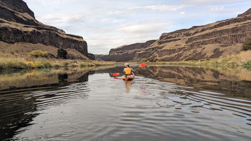 A kayaker enjoys the scenery from her boat on a Columbia and Snake River cruise. (Photo: John Roberts)