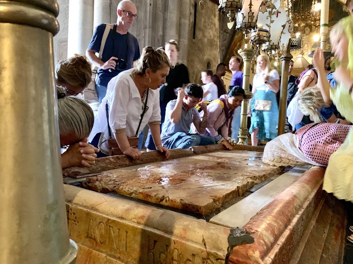 Worshippers touching the Stone of Anointing at the Church of the Holy Sepulchre in Jerusalem