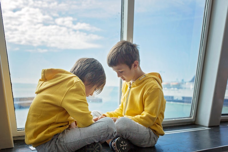 Two young boys wearing matching yellow sweatshirts on a cruise ship
