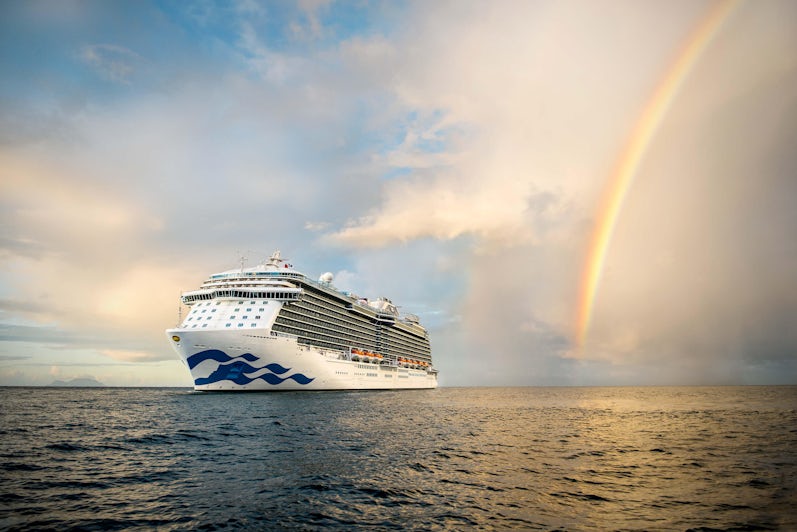 Princess Cruises ship a sea during sunset, with a rainbow in the background