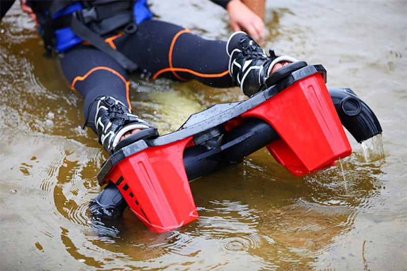 Cropped view of woman wearing flyboard boots and sitting in shallow water before a ride
