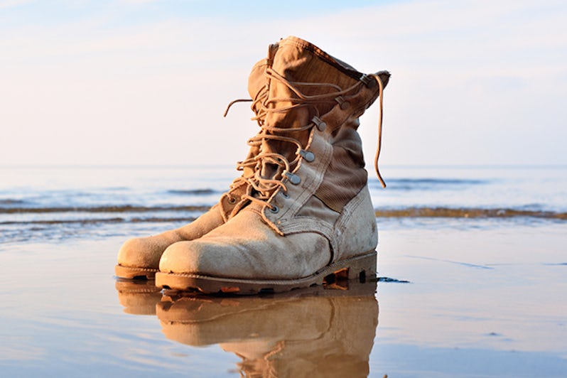 Yellow boots with a shoelaces on a wet sandy beach