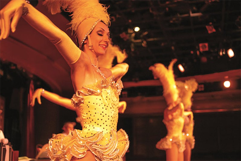 Dancers in cabaret-like outfits dancing in a cruise production