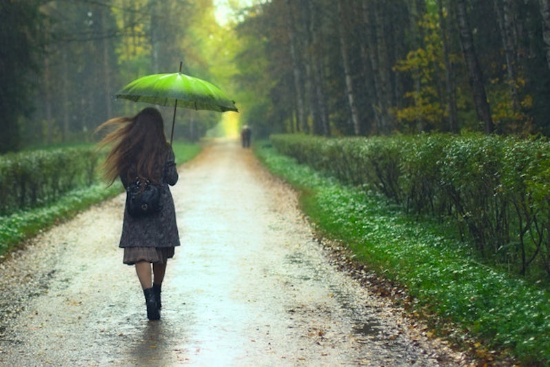 Girl under holding an umbrella in the rain