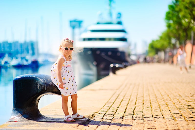 Little girl in port with a luxury liner ni the backgroun