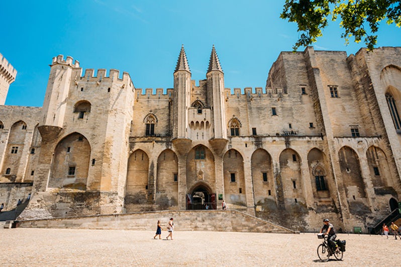 People walking near ancient Popes Palace, Saint-Benezet, Avignon, Provence, France.