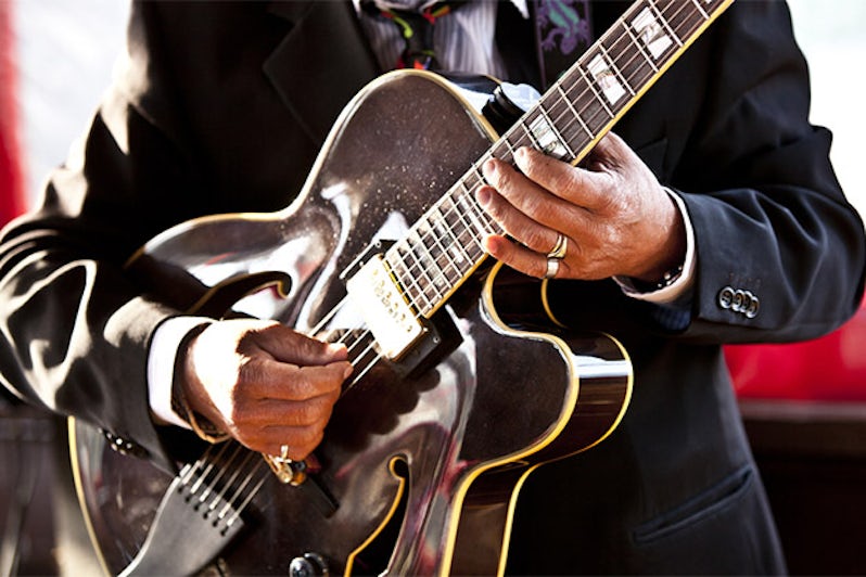 Close up of a blue musician playing the guitar