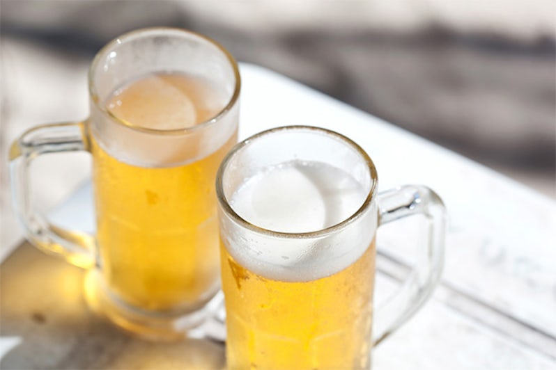 Glasses of cold beer on white wooden table, nobody