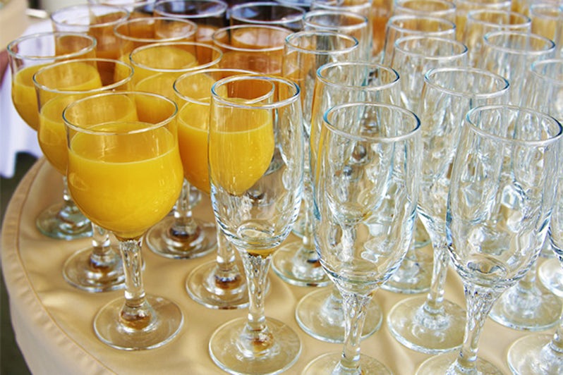 Mimosas and empty glasses on a buffet table
