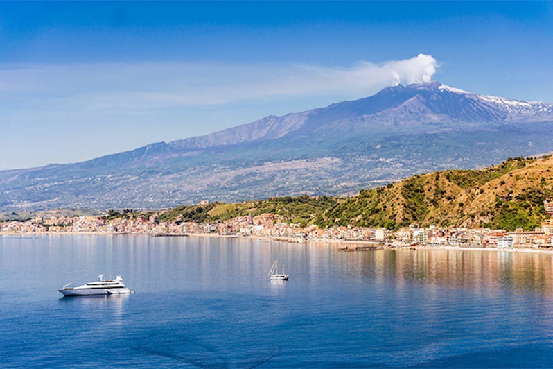 sicilian coastal landscape with cruising boats view from Taormina with the mount Etna in the background