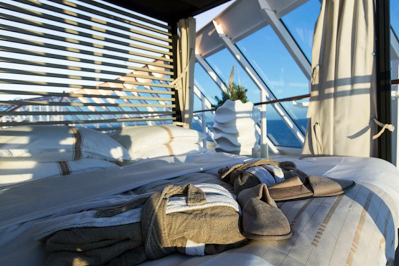 Robes and slippers on an outdoor cabana bed for the Nights in Private Places experience