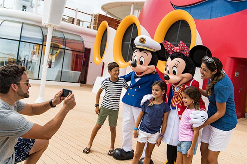 Mickey and Minnie greeting a family on a Disney cruise