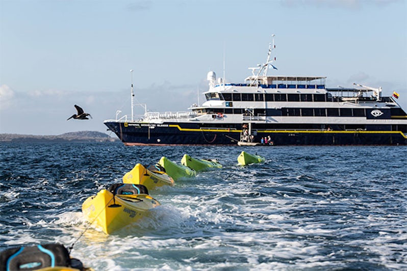 Exterior shot of National Geographic Islander with a row of kayaks in the Galapagos