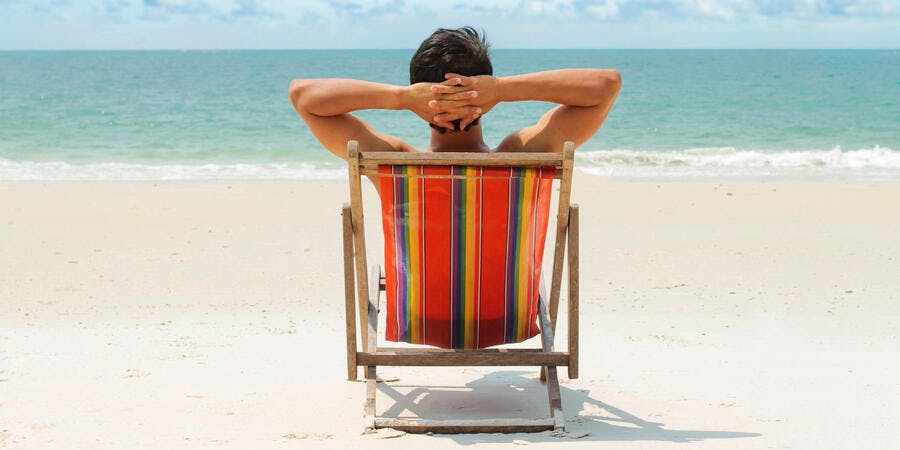 Man lounging on beach (Photo: bluedog studio/Shutterstock) Man lounging on beach (Photo: bluedog studio/Shutterstock)