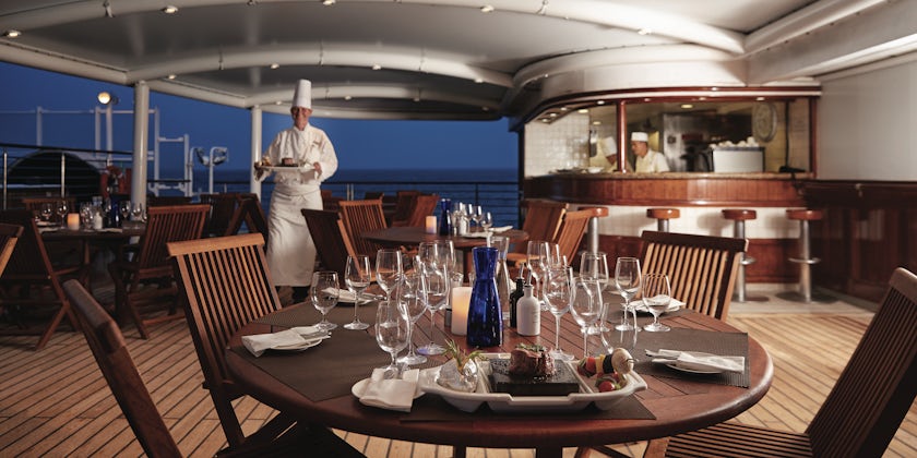 Hot Rocks table setting, with chef in the background on Silversea Cruises