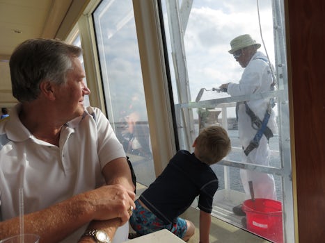 Grandson watching the painter touching-up the ship.