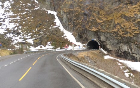 Coach trip on winding roads and through tunnels to top of snowy mountains in Eidfjord