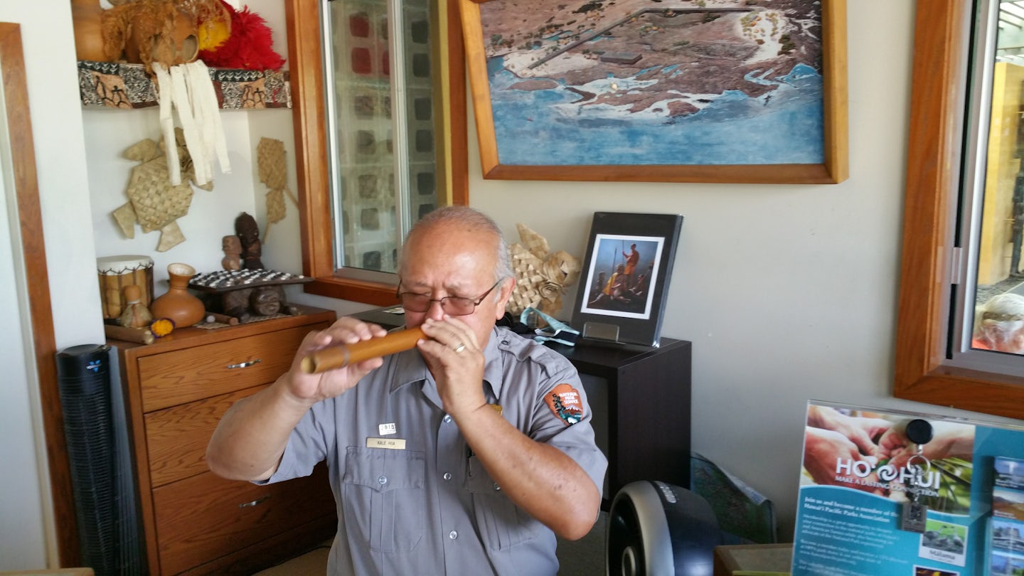 Place of Refuge park ranger playing a flute-like instrument