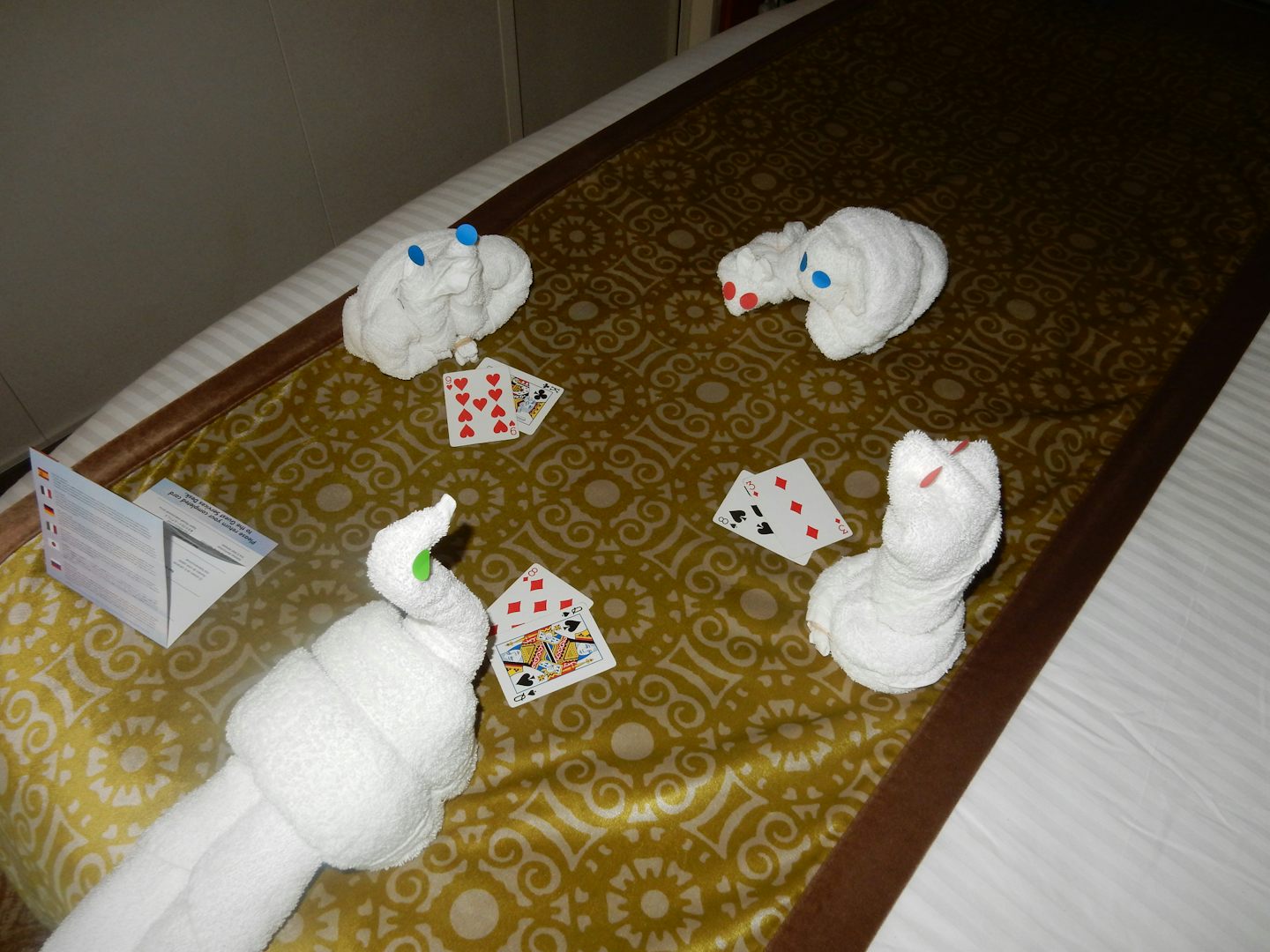 Towel animals playing cards on the bed