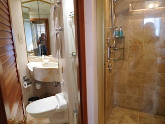 Double sided bathroom.  Toilet and sink in one with a door leading to a sta