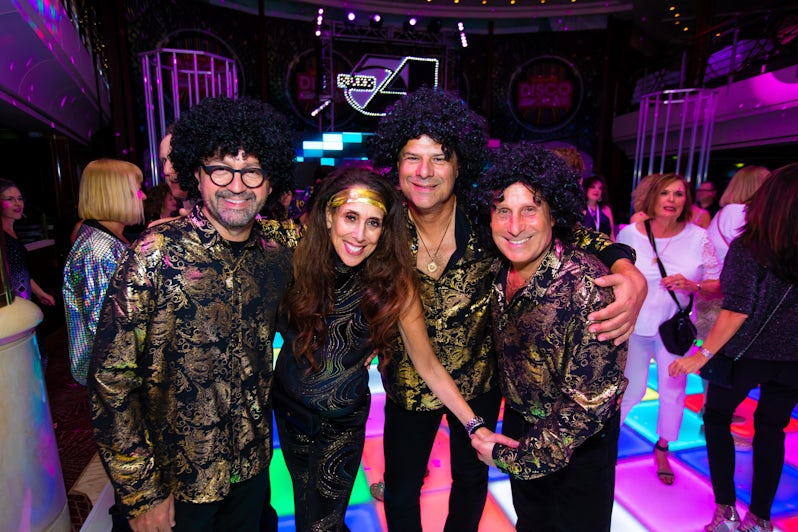 Four adult passengers dressed up in disco attire and costumes on the Ultimate Disco Cruise