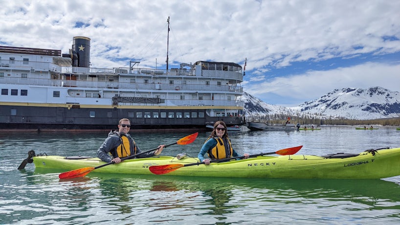 Couple in kayak in Alaska in front of Wilderness Legacy by UnCruise Adventures (Photo: Colleen McDaniel)