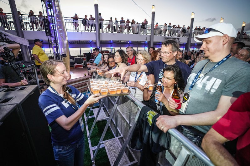 Woman passing out alcoholic drinks to fans at an onboard Bon Jovi concert