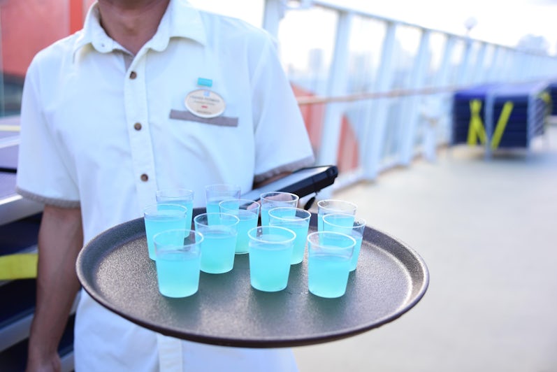Waiter holding free blue shots at sail-away