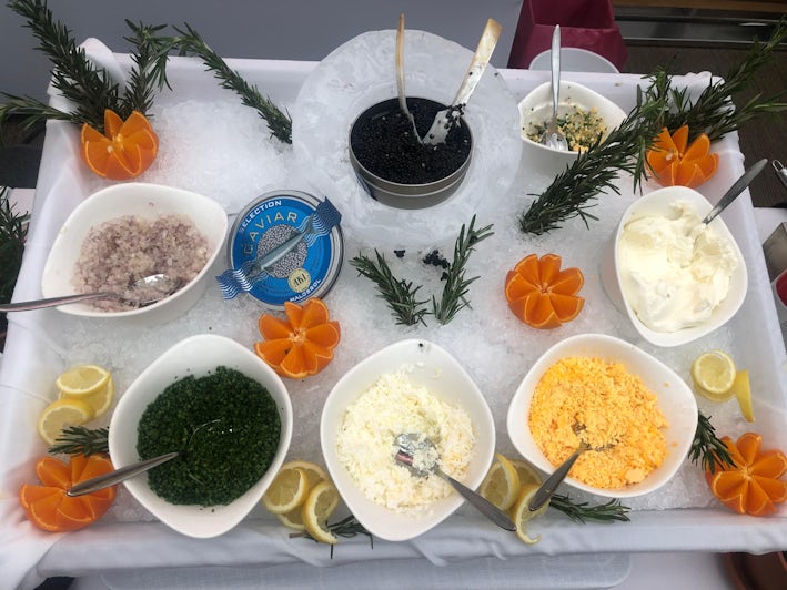 Overhead shot of a decorative caviar and condiment spread at the Pool Grill