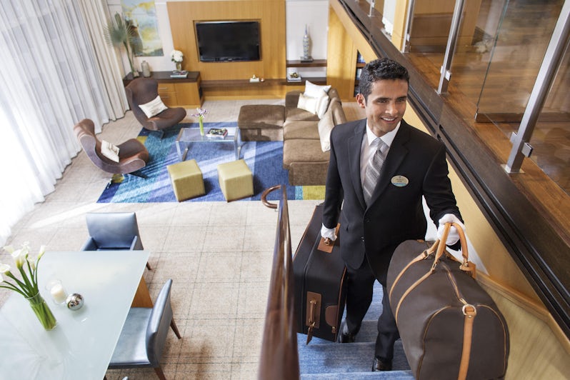 Royal Genie butler helping guests check in to a Royal Caribbean Loft Suite (Photo: Royal Caribbean)