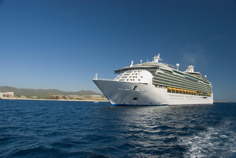 Photograph: A Cruise ship docked in Cabo San Lucas, Mexico. The beach and condominiums are in the background. - Photography by tose via Shutterstock