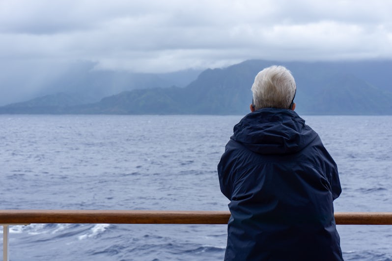 A passenger aboard Pride of America watches sailaway on a misty day in Hawaii (Photo: Aaron Saunders)