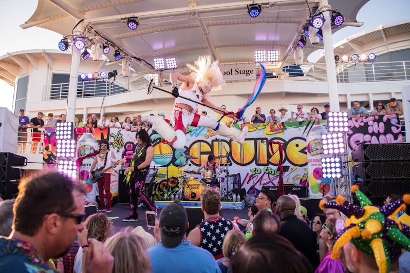 Performer jumping in mid-air during a performance on the 80s cruise