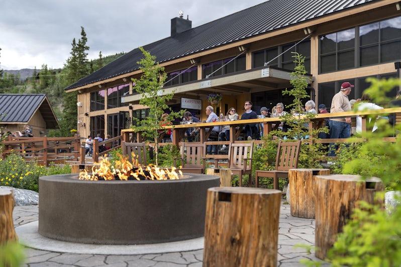People eating in front of a fire pit in Denali Square