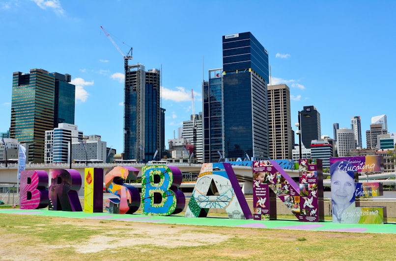 Letters making Brisbane sign in South Bank Parklands, with modern buildings in the background.