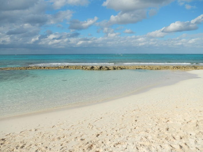 Calm waters and white sand of Love Beach in Nassau on a sunny day