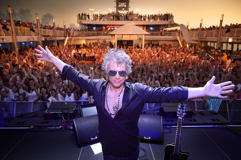 Jon Bon Jovi posing onstage, with hundreds of fans in the background, on the Bon Jovi cruise