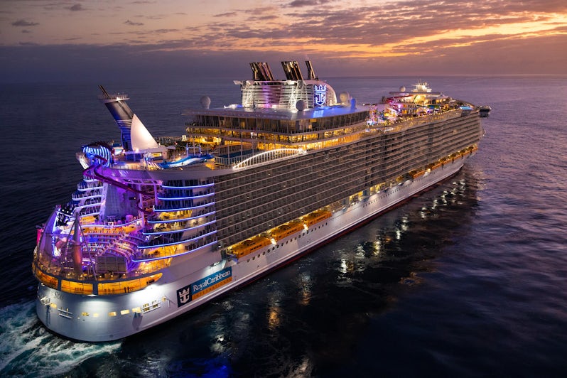 Exterior shot of a lit-up Oasis of the Seas sailing at sunset
