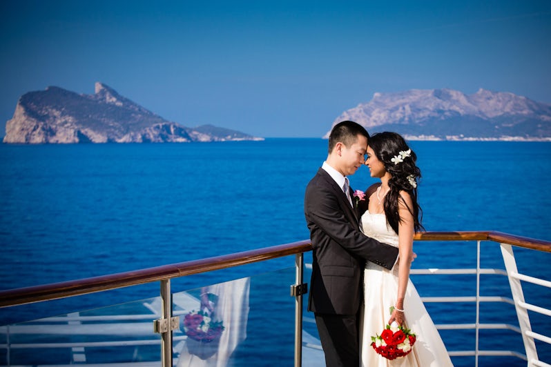 Asian couple posing in wedding attire on the sun deck on Allure of the Seas