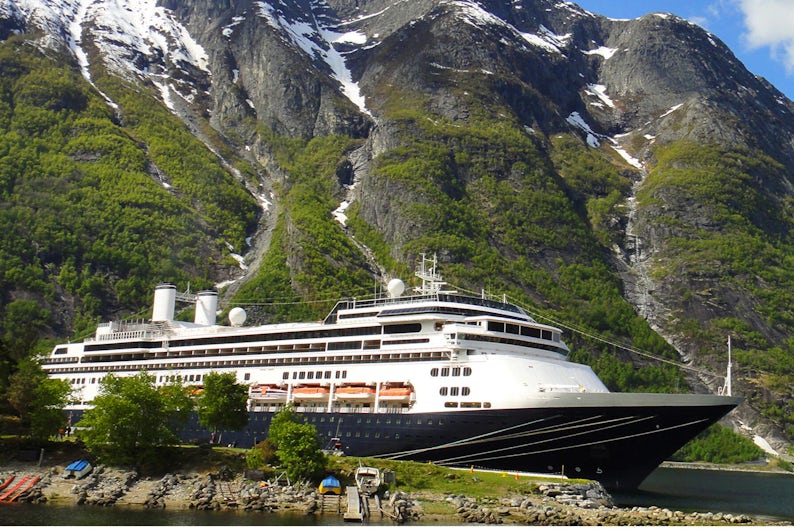 Borealis cruise ship in front of mountains and waterfalls in the Norwegian fjords