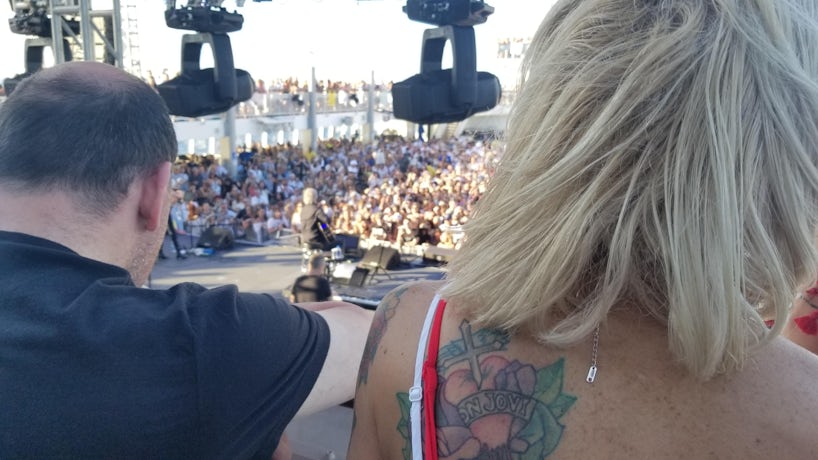 Photo of a blonde woman with a faded Bon Jovi tattoo on her left shoulder blade