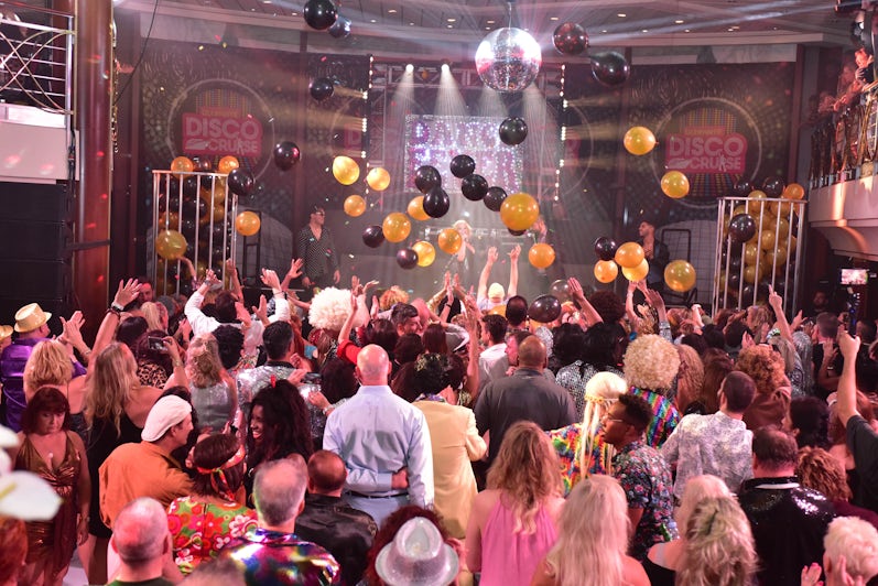 Passengers dressed up in Studio 55, with balloons and decorations from the ceiling, on the Ultimate Disco Cruise
