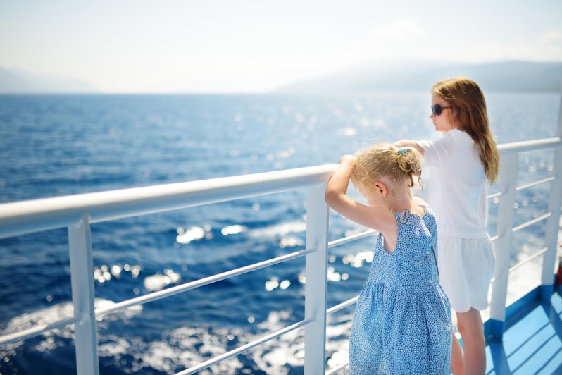 Young girls staring at the deep blue sea from a cruise ship railing