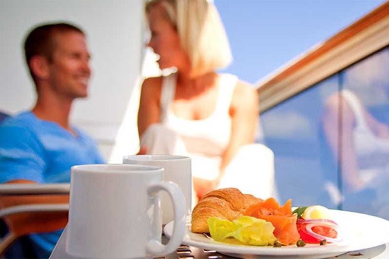 Couple eating room service on cruise balcony