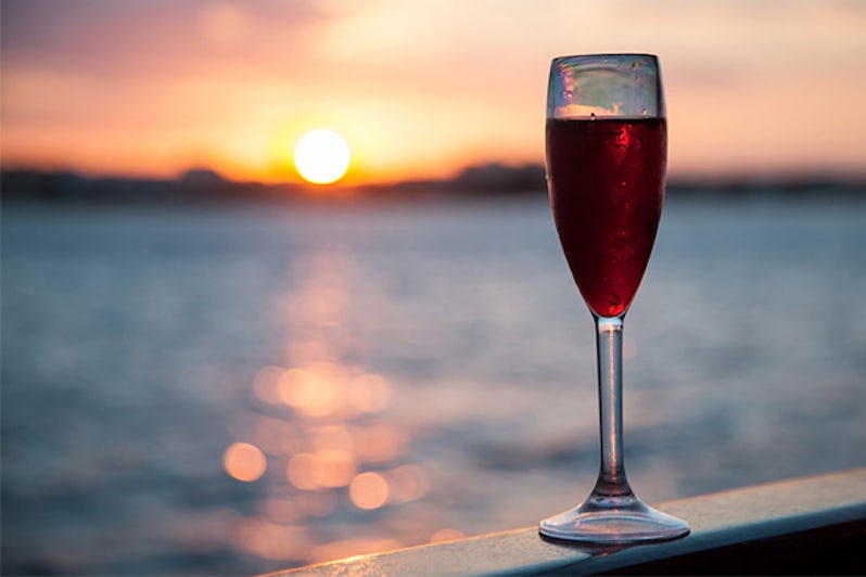 Goblet with red wine on ocean or river background