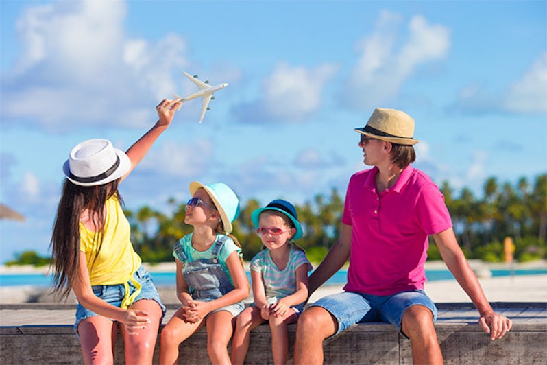 Family in tropical destination flying a toy plane